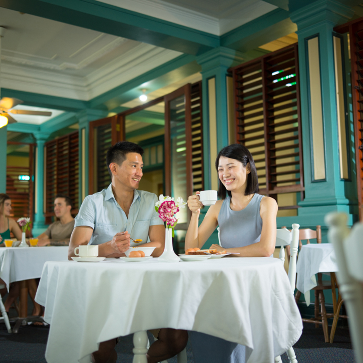 Couple enjoying coffee in the heritage dining room at Hides Hotel Cairns